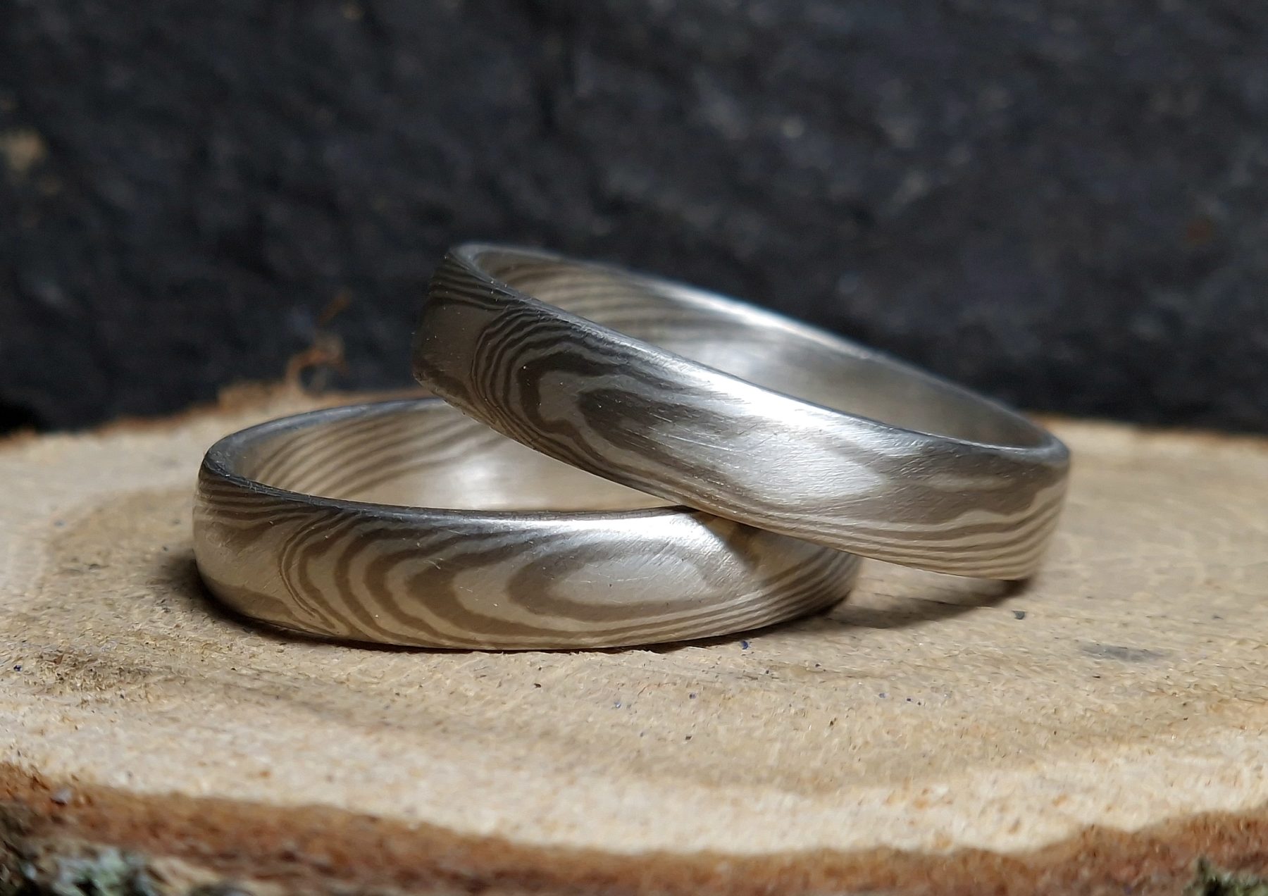 Mokume gane prsteny s klasickým vzorem, napodobujícím strukturu dřeva. Bílé paladiové zlato 585/1000, stříbro 925/1000, 15 vrstev.