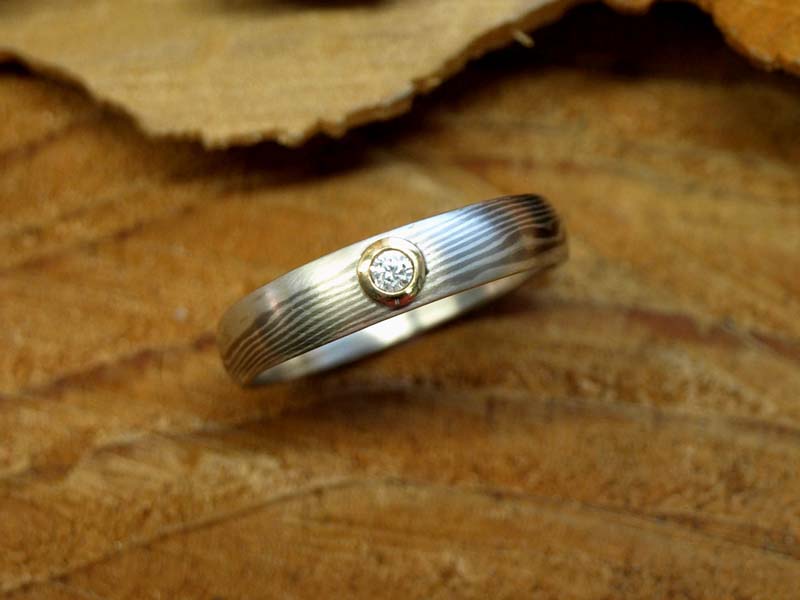 Mokume gane prsten s klasickým vzorem, napodobujícím strukturu dřeva. Bílé paladiové zlato 585/1000, stříbro 925/1000, 2mm diamant