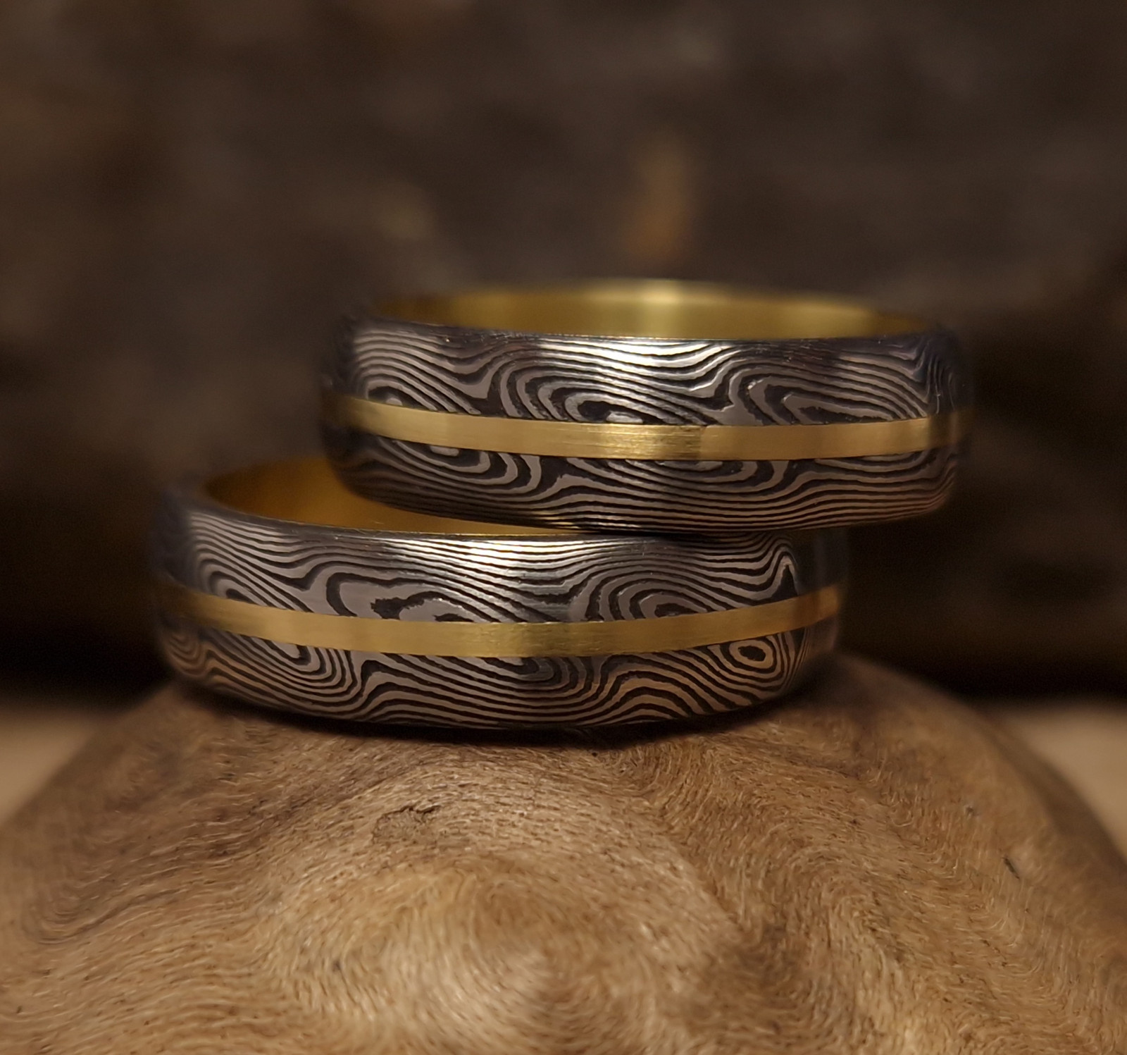Prsteny ze zlata a oceli damasteel (se zlatym pruhem a zlatým vložkováním].