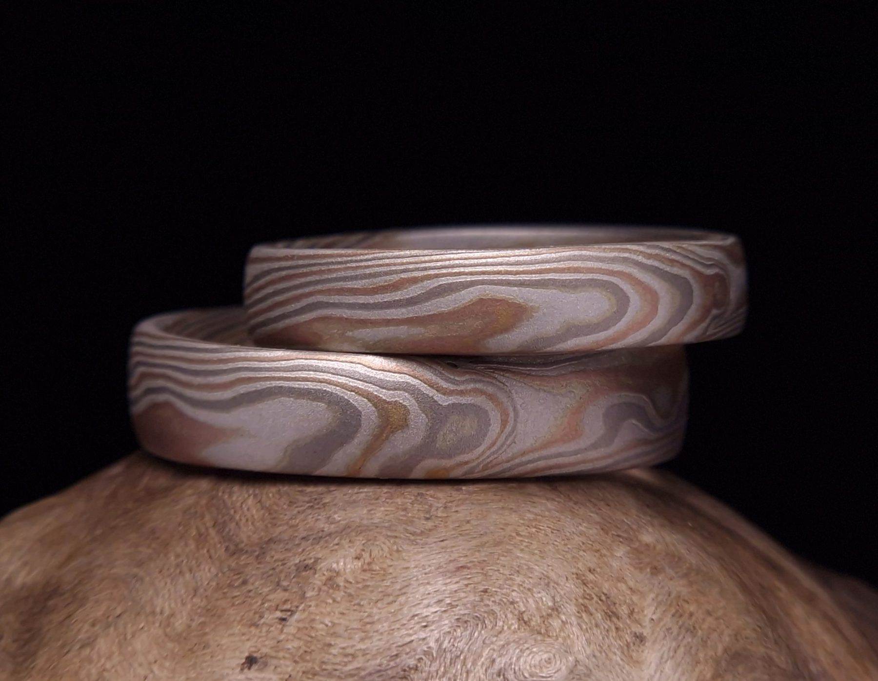 Mokume gane prsteny, vyrobené z vrstev bílého paladiového zlata 585 , červeného zlata 585 a stříbra. Klasický mokume gane vzor, připomínající léta dřeva.